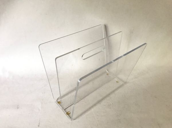 Clear acrylic mid-century modern W-shaped magazine rack featuring a handle and 3-tier bookshelf design