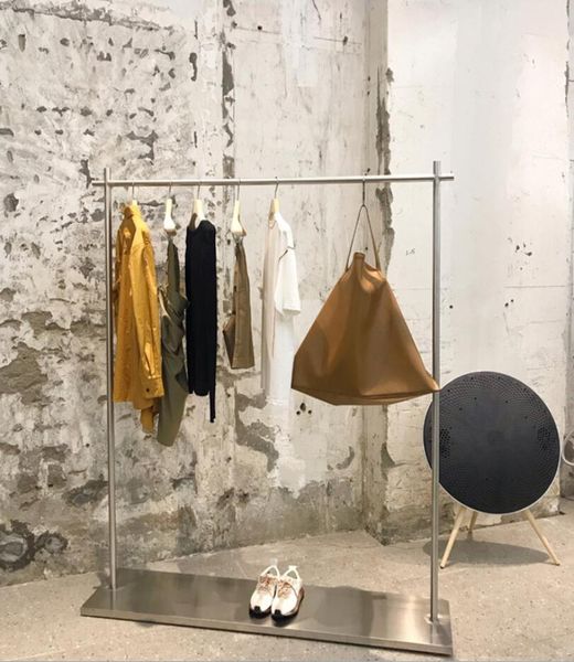 Commercial furniture display rack with stainless steel base and side hangers for women's clothing