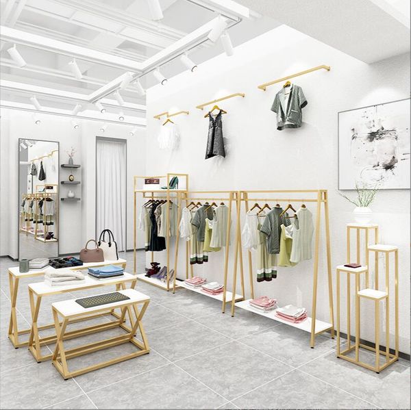 Golden wall-mounted and freestanding clothing racks for women's apparel, featuring a simple double-sided hanger design