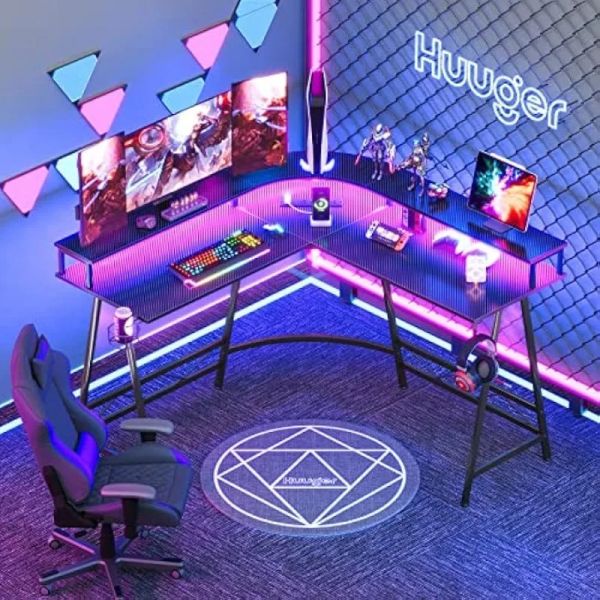 L-shaped gaming desk featuring LED lights, power outlets, and monitor shelves for home office use
