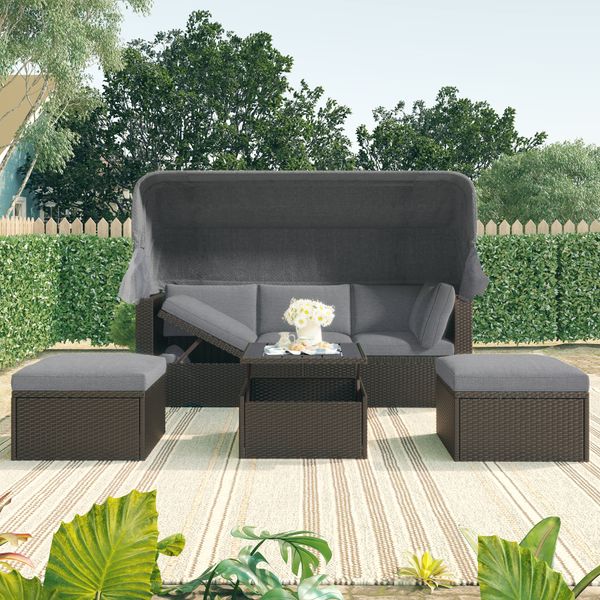 Rectangular outdoor daybed featuring a retractable canopy and wicker sectional seating