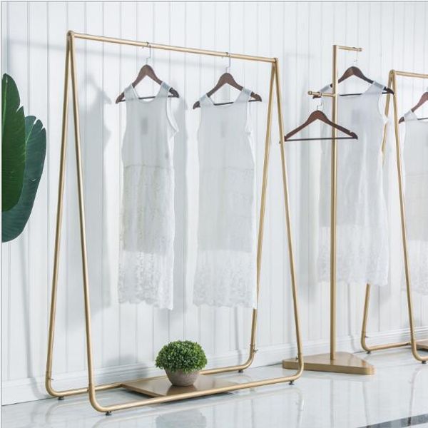 Simple iron clothing racks for bedroom floors with layered shelves displaying men's and women's apparel