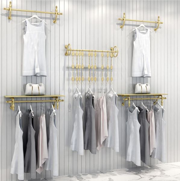 The clothing store's display rack features gold wall-mounted shelves for hanging children's clothes in the mall
